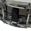 Close-up of steel snare drum with drum key and tension rods.