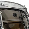 Close-up of a shiny steel snare drum with tuning hardware.