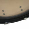 Close-up of drum skin with black dots and metal hardware.