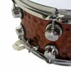 Close-up of hammered steel snare drum with chrome hardware and tuning lugs.