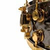 Close-up of Mapex Black Panther 14x6.5in hammered brass snare drum hardware.