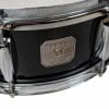 Close-up of Gretsch snare drum badge with black finish and chrome hardware.