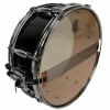 Black and chrome snare drum with wooden interior and logo.