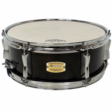 Black Yamaha snare drum with chrome hardware and white drumhead.