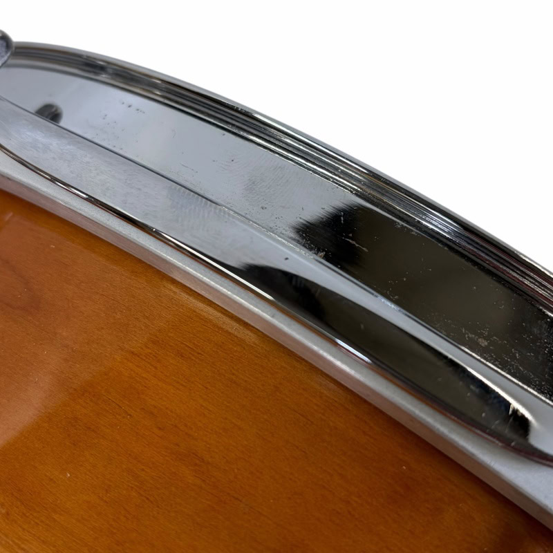 Close-up of a Mapex Black Panther Cherry/Maple 12x7in snare drum rim.
