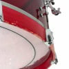 Close-up of a red acrylic drum shell with hardware details.