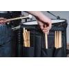 Drummer's stick bag with drumsticks and drum kit in background.