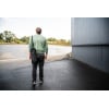 Man walking outdoors with a black drumstick bag over his shoulder.