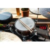 Snare drum with drumsticks on top, part of a drum kit setup.