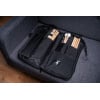 Meinl Pro Stick Bag with drumsticks on a grey sofa.