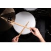 Close-up of a drummer's hands holding drumsticks over a drum kit.