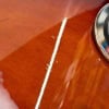 Close-up of a drum shell with a white line and metallic hardware.