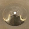 Close-up of a Sabian AAX 16in Bright Crash cymbal showing its shiny surface and circular grooves.
