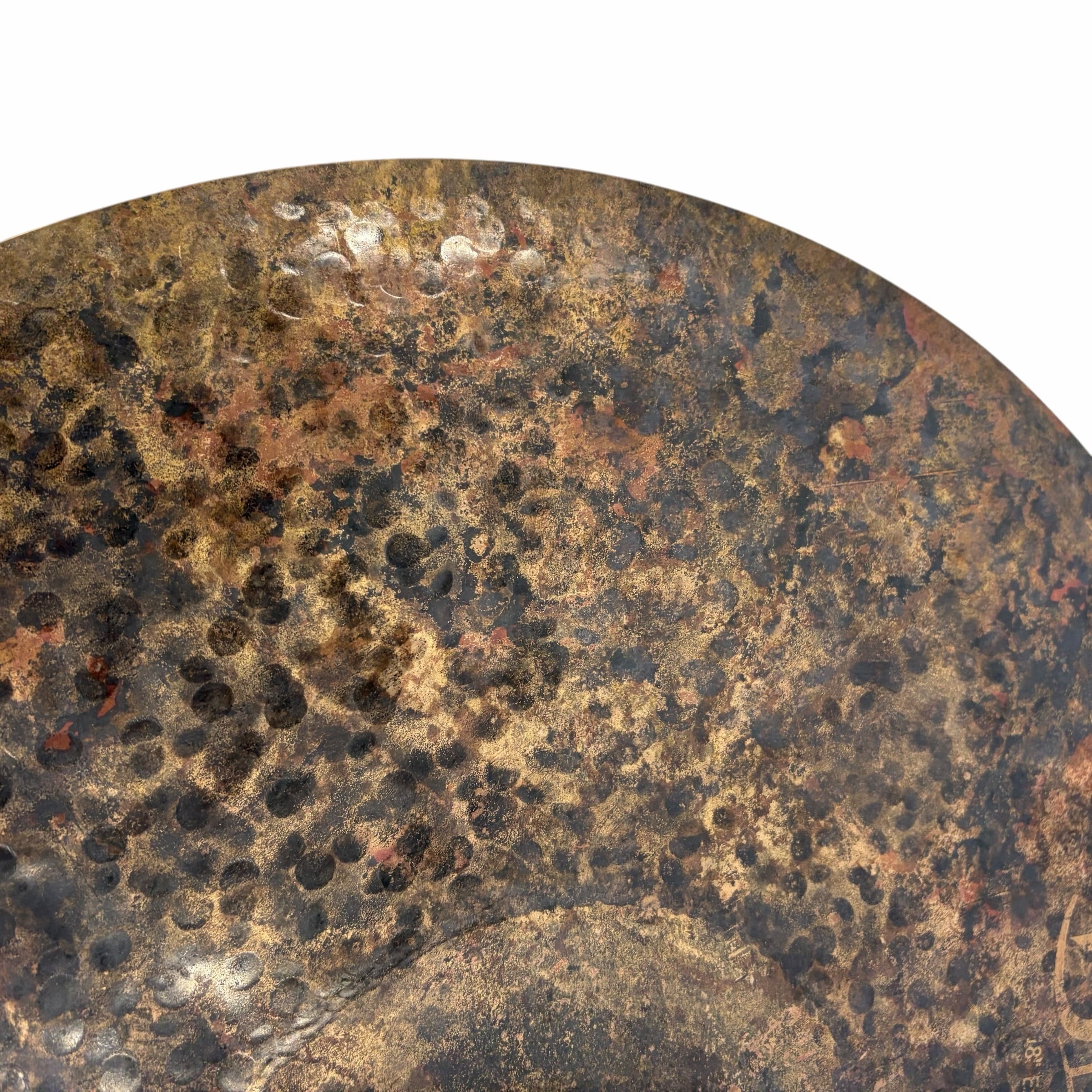 Close-up of a rusted crash cymbal with textured surface.