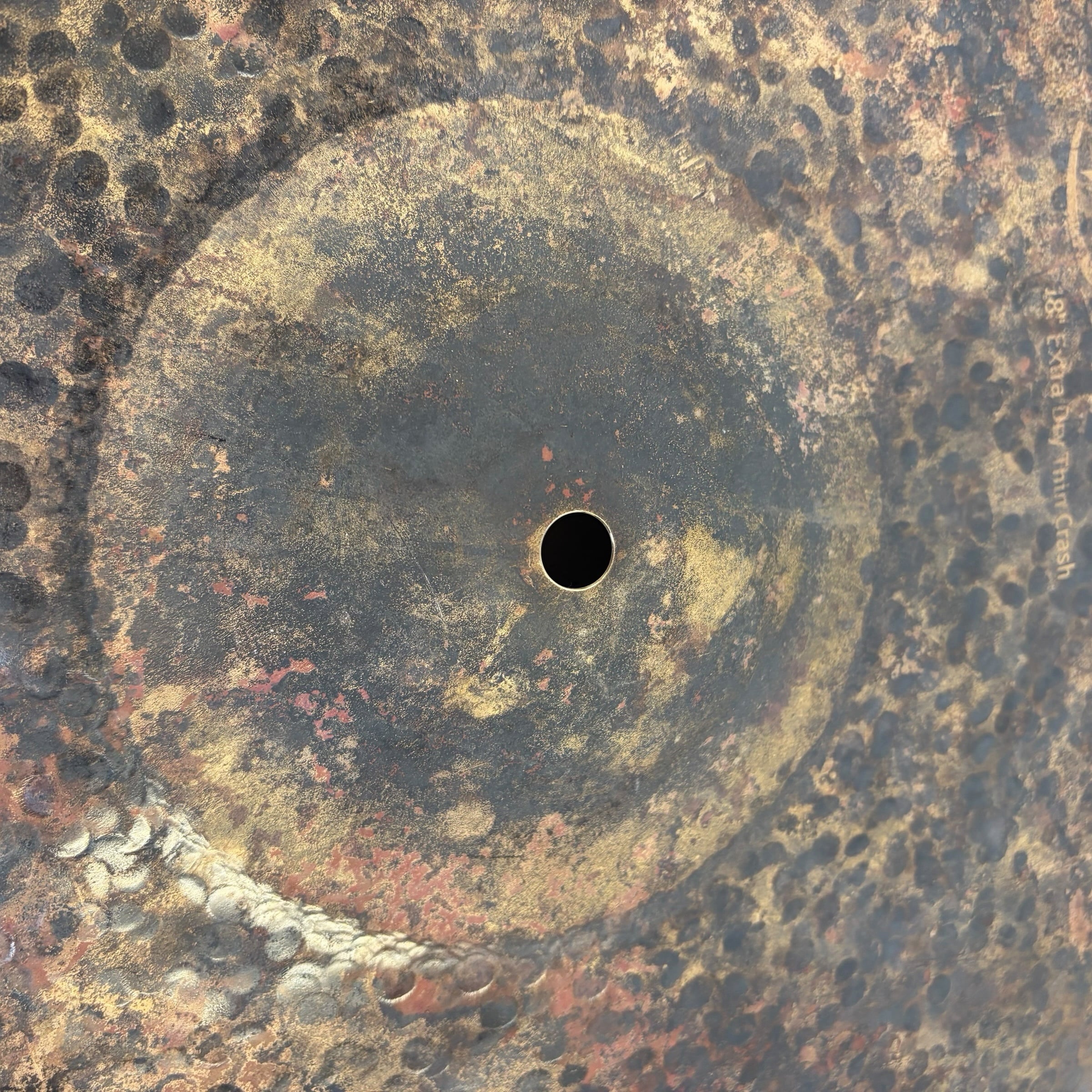 Close-up of a vintage crash cymbal with rust and patina.