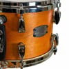 Close-up of Yamaha drum shell with wood finish and hardware.