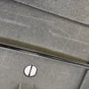 Close-up of a grey hardware case with a wheel and screw.