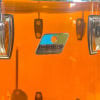Ludwig Vistalite drum set badge close-up on orange shell.