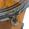 Close-up of drum shell hardware and tom mount on orange drum.