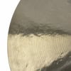 Close-up image of a brass cymbal showing circular lathe marks and edge.