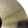 Close-up of bronze cymbal with circular grooves and subtle patina.