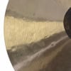 Close-up image of a polished cymbal with circular grooves and reflections.