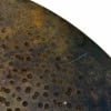 Close-up of a vintage rusted cymbal with patina and surface marks.