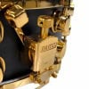 Close-up of gold Mapex Black Panther snare drum hardware and tuning mechanism.