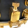Close-up of gold Mapex Black Panther snare drum hardware and tuning knob.