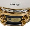 Close-up of Mapex Black Panther 14x5.5in maple snare drum with gold hardware.