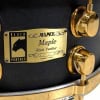 Close-up of Mapex Black Panther 14x5.5in Maple Snare Drum with gold hardware.